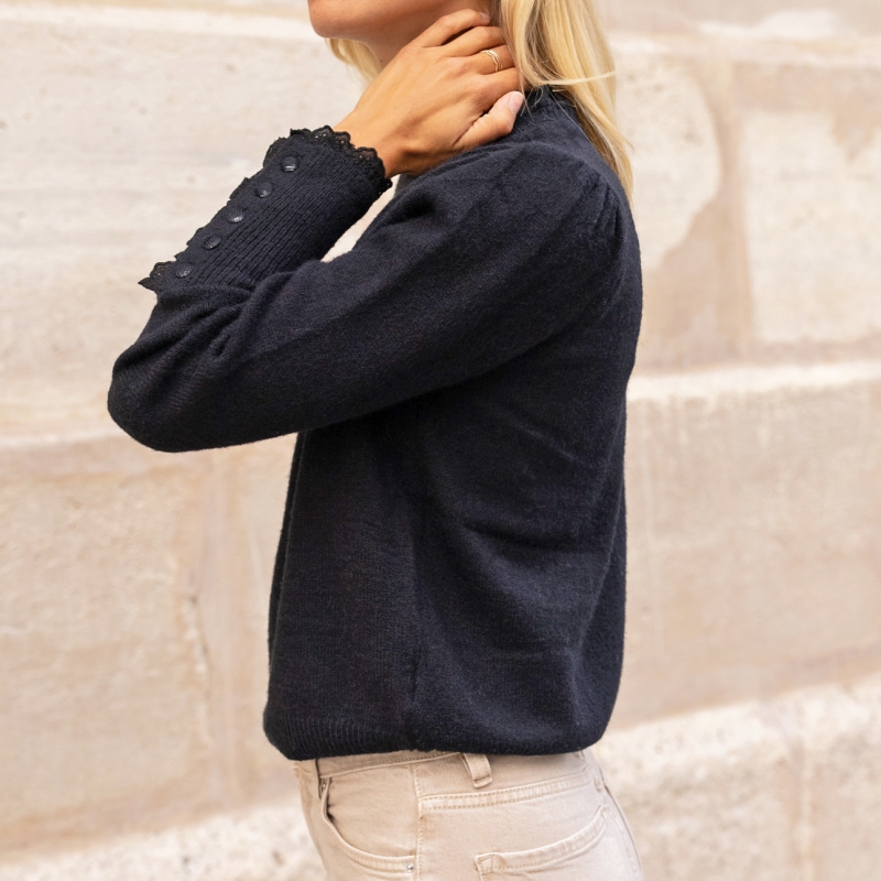 Détail boutons poignets – pull noir femme